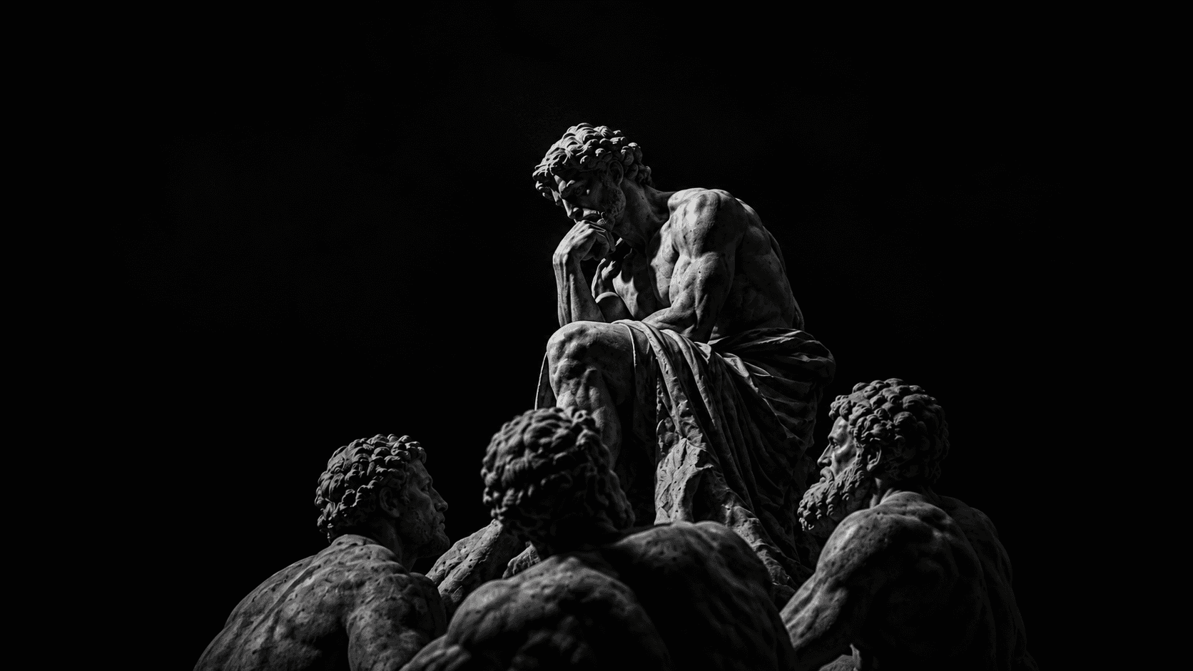 A seated sculpted thinker above three gathered figures.